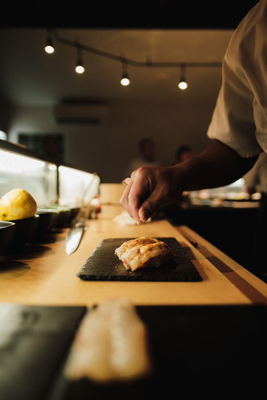 Chef preparing sushi at wooden counter
